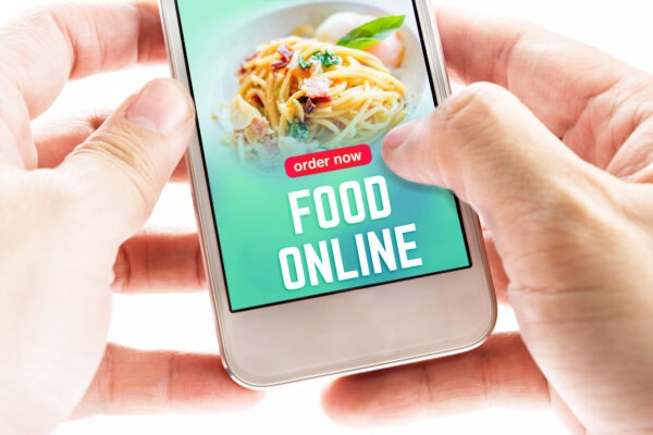 Close up Two hand holding mobile phone with food online word and icons, Digital Marketing concept.