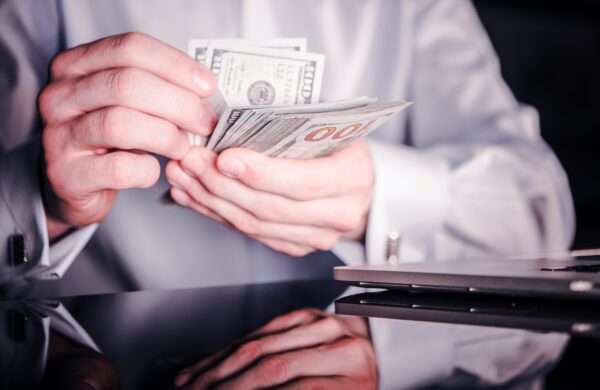 Banker Counting Cash Money. Caucasian Bank Worker with Dollar Banknotes in Hands. Closeup Photo.